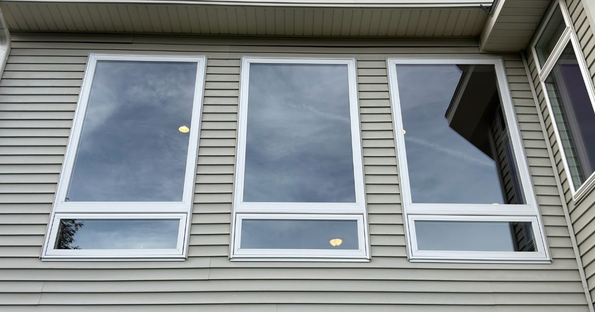 Three newly installed Andersen 100 Series picture over awning windows with white exterior frames