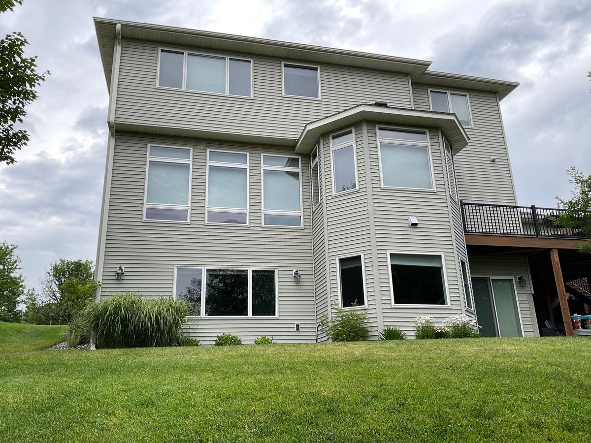 Three-story home rear exterior with lap siding, white trim, and replacement windows