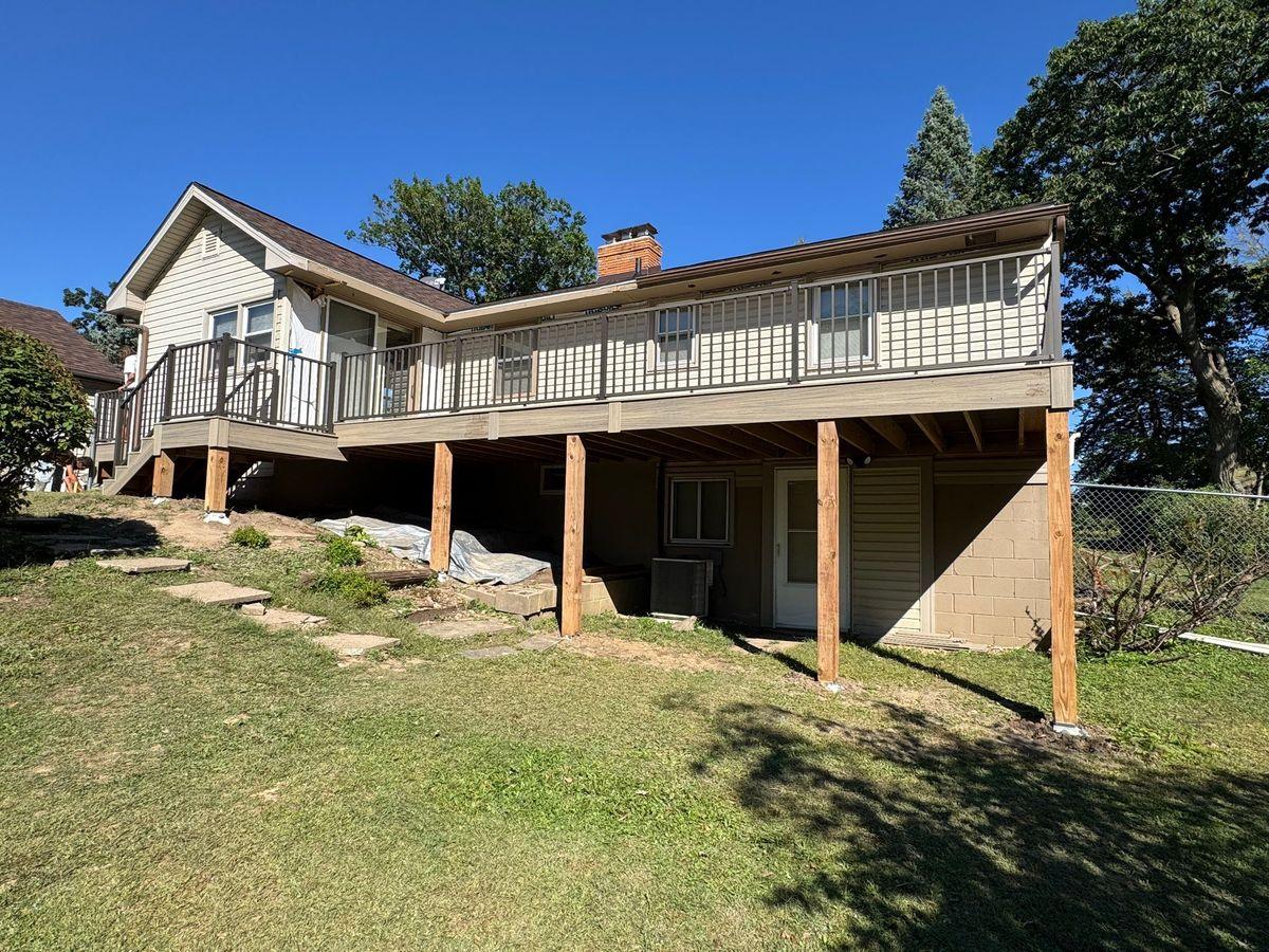 Newly built elevated L-shaped composite deck with black metal railing