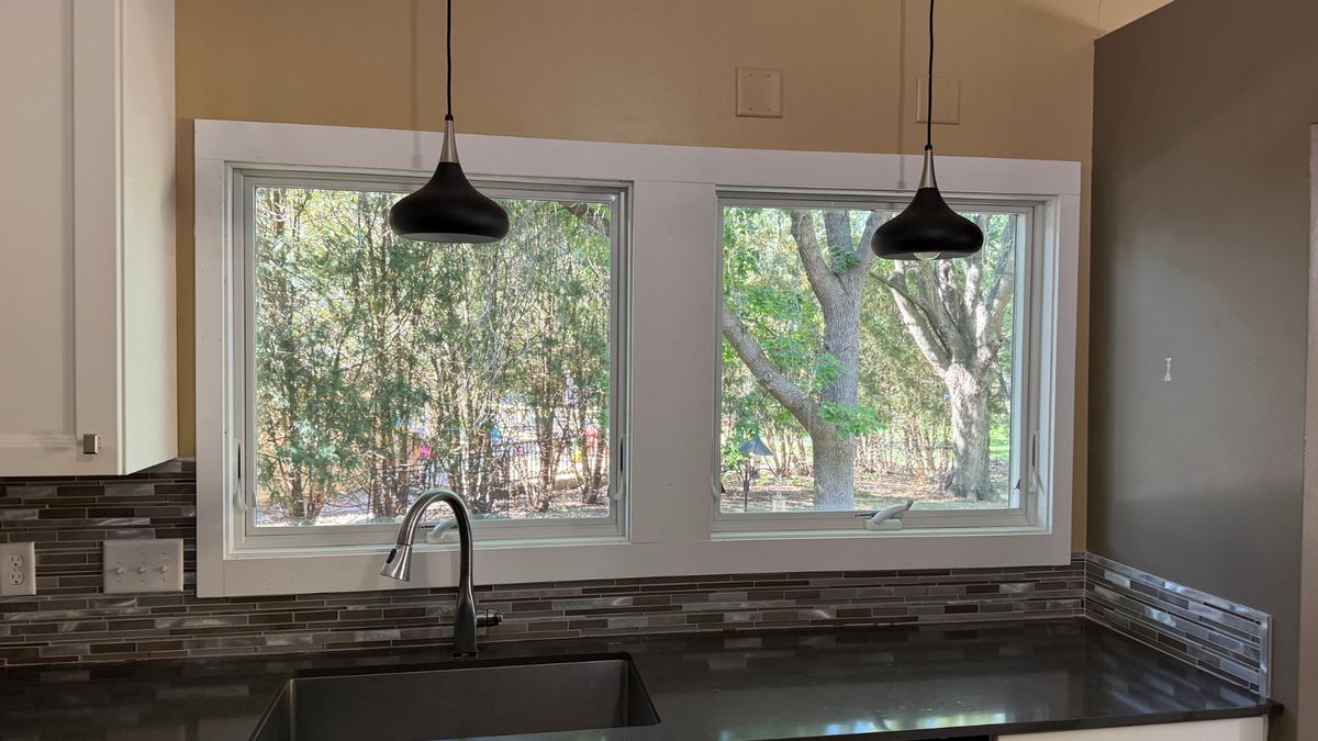 New white-trimmed Andersen casement windows installed over a kitchen sink in Minnetonka, MN