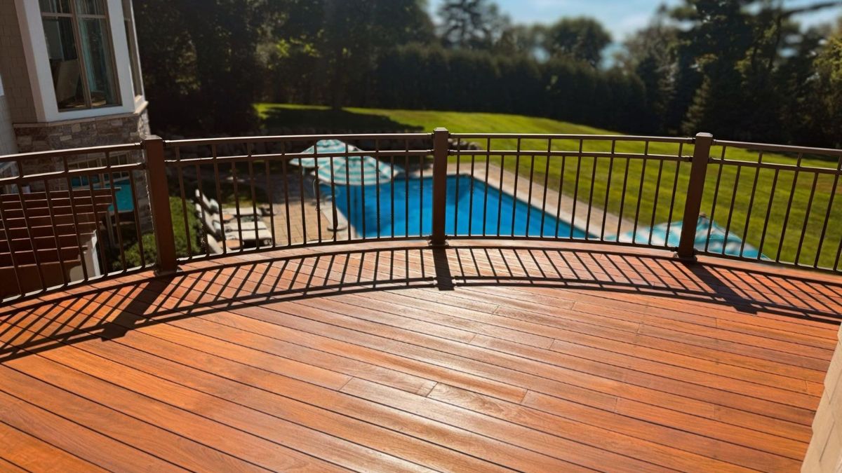 Sanded and refinished curved cedar deck with bronze metal railing in Wayzata, MN